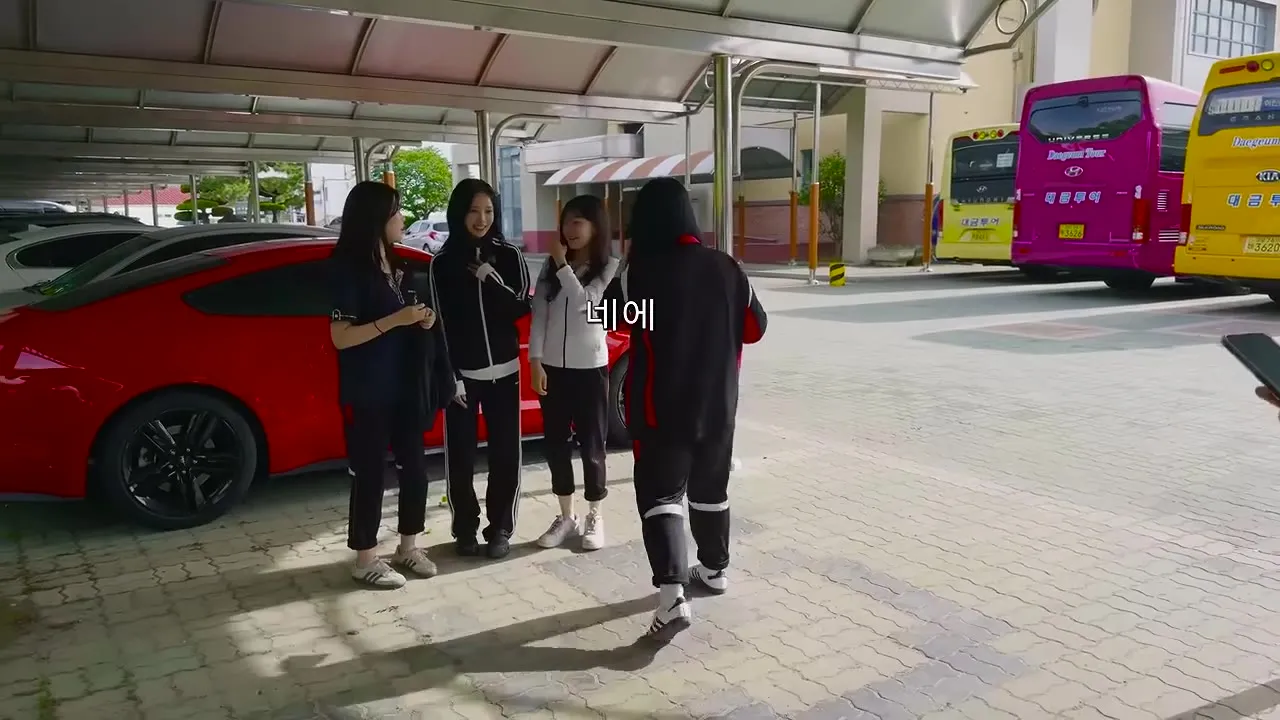 통학버스 앞에서 학생들과 이야기하는 모습
