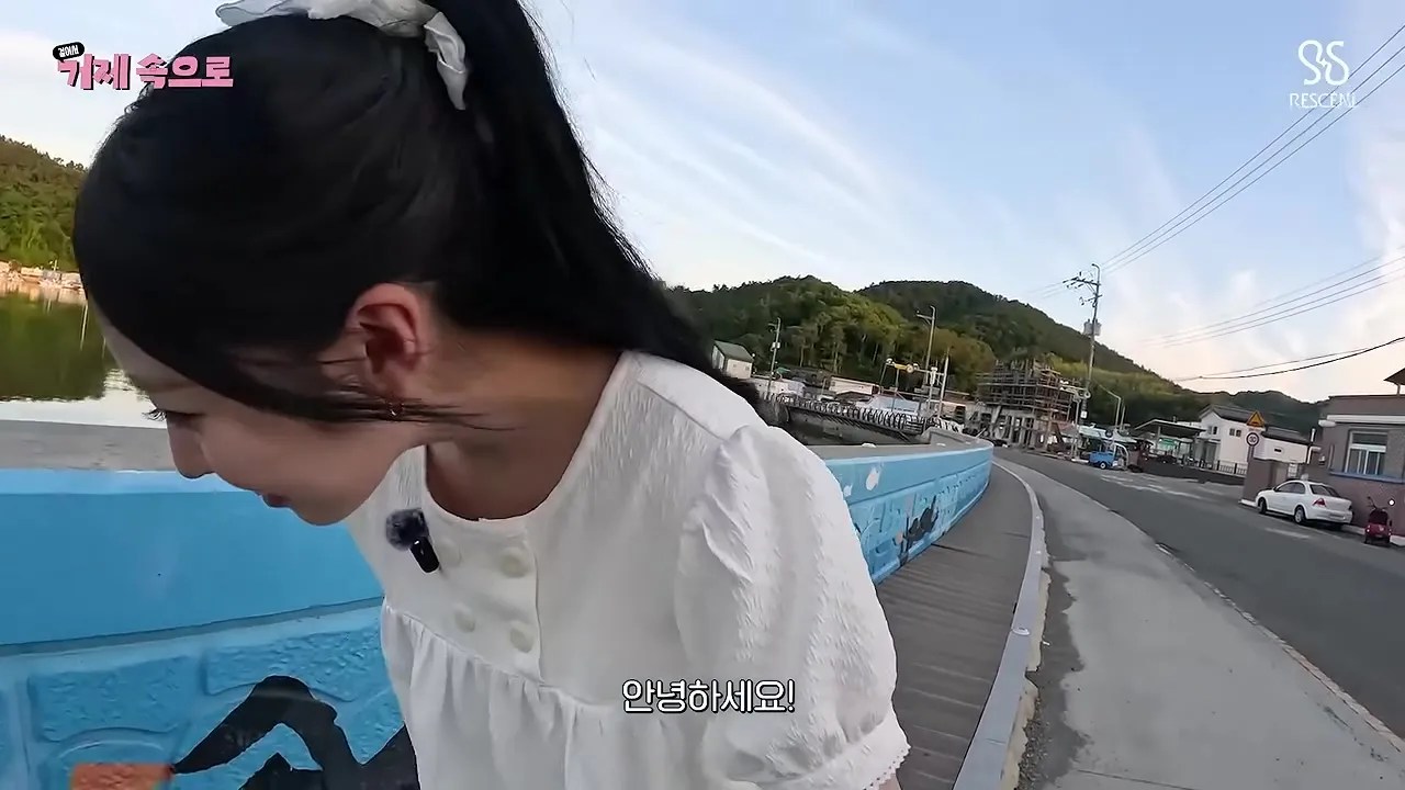 바닷가 길을 혼자 걸으며 인사하는 장면